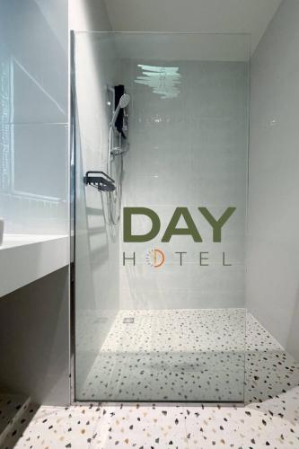 a bathroom with a shower with a day united sign on the wall at โรงแรมเดย์โฮเต็ล in Khon Kaen