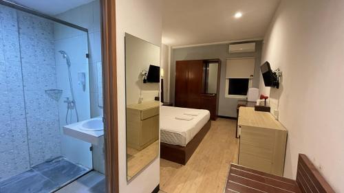 a bathroom with a bed a sink and a shower at Vu Exclusive Boarding House in Kerobokan