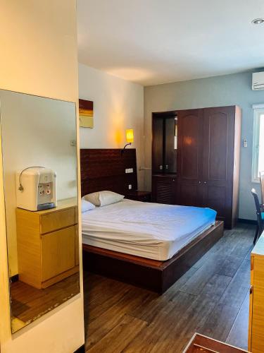 a bedroom with a bed and a mirror at Vu Exclusive Boarding House in Kerobokan