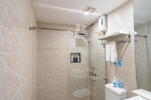 a bathroom with a shower and a toilet at Kuadro Hotel & Suites in Moalboal