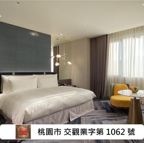a bedroom with a large white bed and a yellow chair at Monarch Plaza Hotel in Taoyuan
