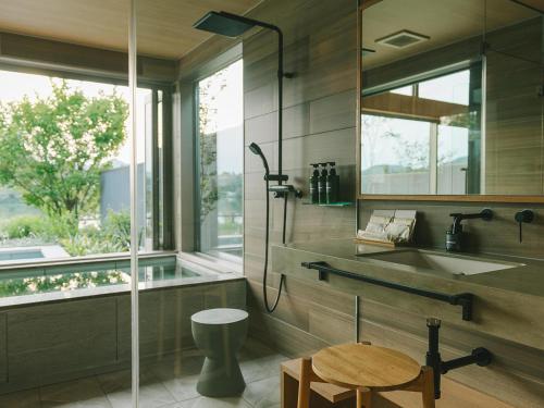 a bathroom with a shower and a sink and a window at HOTEL & KOTEI SOKA in Kyotango
