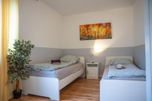 a room with two beds and a painting on the wall at OMNI - Homes - Waldstraße in Falkensee