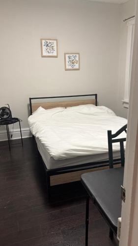 a bedroom with a bed with white sheets and a table at Casa Toronto in Toronto