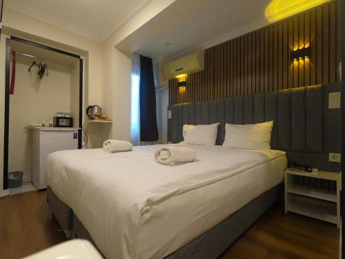 a bedroom with a large bed with two towels on it at Naila Hotel in Istanbul