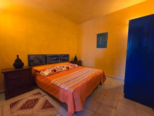 a bedroom with a bed and a yellow wall at Villa Patrizia in Taviano