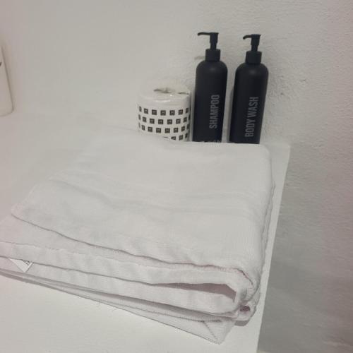 a pile of towels sitting on a shelf with two bottles at Loft Garden Santiago México in Santiago