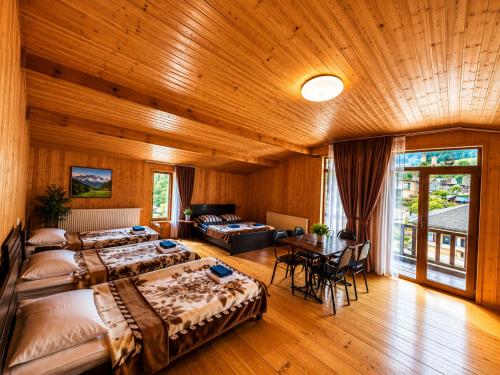 a large room with two beds and a table at Daeli Hotel in Mestia