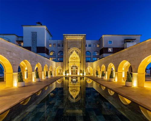 a courtyard of a building with a pool of water at Kempinski Hotel The Dome Belek in Belek