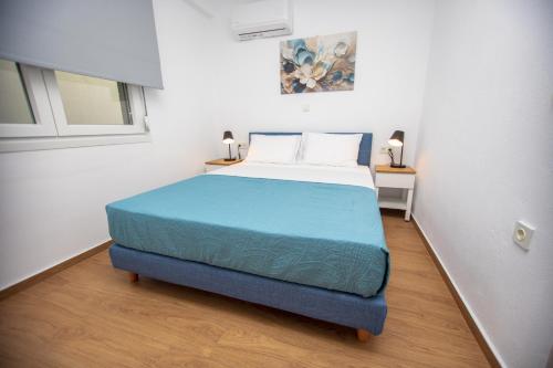 a bedroom with a blue bed in a white room at Green Almond D1 in Orfánion