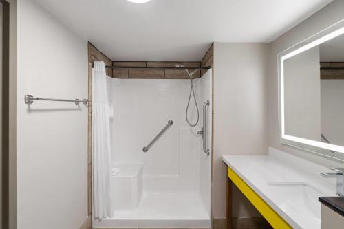 a white bathroom with a shower and a sink at Days Inn by Wyndham Clanton AL in Clanton