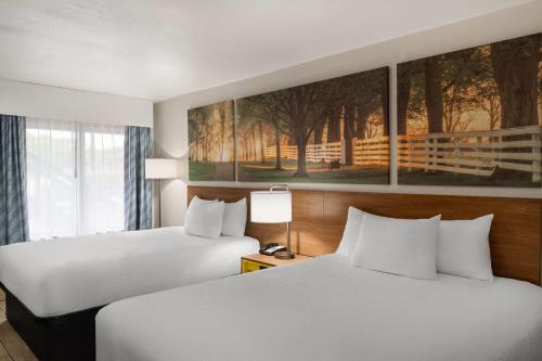 a hotel room with two beds and a painting on the wall at Days Inn by Wyndham Clanton AL in Clanton