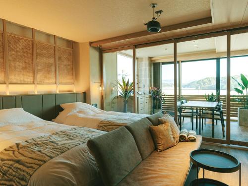a bedroom with a bed and a couch and a table at HOTEL & KOTEI SOKA in Kyotango