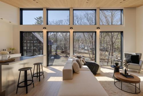 a living room with a white couch and a large window at Kuro Hakuba in Hakuba