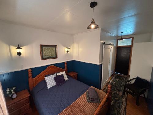 a bedroom with a bed with a blue wall at Tin Town suites in Herberton