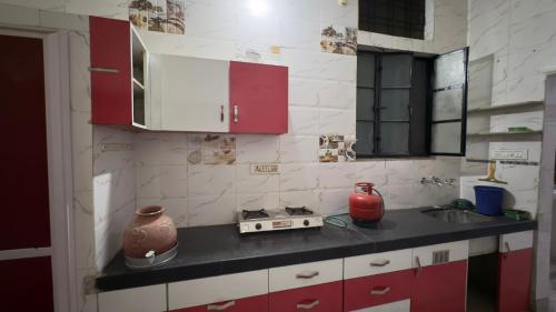 a kitchen with red and white cabinets and a counter top at Hardik villa in Udaipur