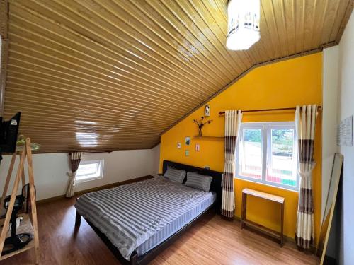 a bedroom with a bed with a wooden ceiling at TeeDalat House in Khu Chi Lăng