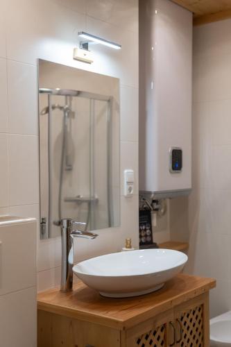 a bathroom with a white sink and a shower at Herzerl Apartment - Heiligenblut in Heiligenblut