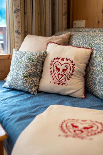 a bed with two pillows with hearts on it at Herzerl Apartment - Heiligenblut in Heiligenblut