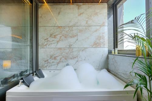 a bathroom with a tub and a glass shower at Stay XO - A Luxurious 3BHK Villa in Panchkula in Panchkula