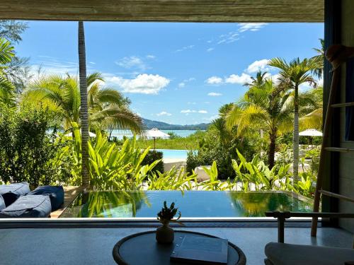 ein Zimmer mit Blick auf einen Pool und Palmen in der Unterkunft Cape Pakarang Wow Wild Wellness Escapes in Khao Lak