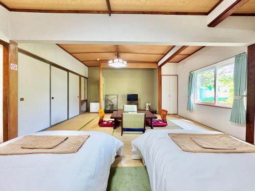 a bedroom with two beds and a living room at Hotel Sol at Lake Toya in Lake Toya