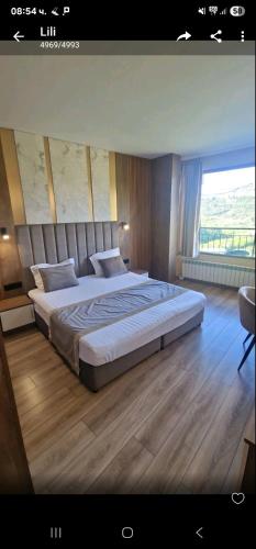 a bedroom with a large bed with a large window at Lucky Hotel in Veliko Tŭrnovo