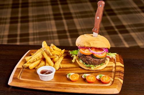 a hamburger and french fries on a wooden tray at Helix Hotel in Grangemouth