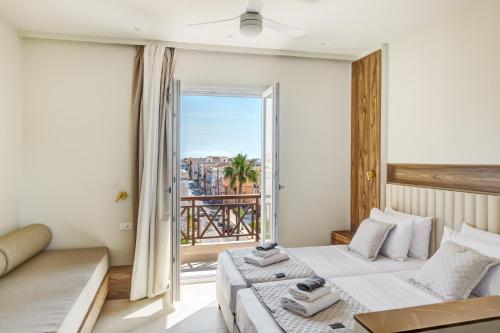 a bedroom with two beds and a large window at Arxontissa Rooms in Ermoupoli