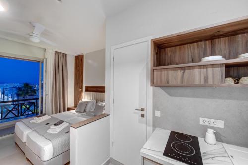 a bedroom with a bed and a view of the ocean at Arxontissa Rooms in Ermoupoli
