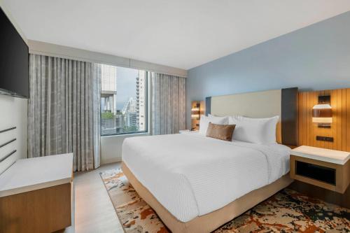 a bedroom with a large bed and a large window at Cambria Hotel Austin Downtown in Austin