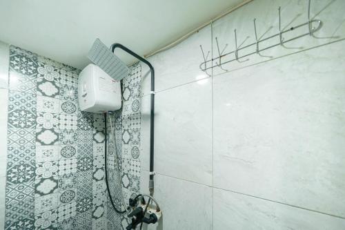 a bathroom with a shower with a blow dryer at JM Guest House Lamaran RedPartner in Karawang