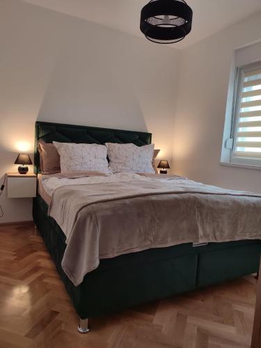 a bedroom with a large bed with a green headboard at Green Diamond in Vrnjci