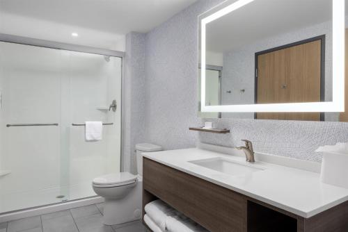 a bathroom with a sink and a toilet and a mirror at Home2 Suites By Hilton Salisbury Fruitland in Fruitland