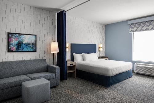a hotel room with a bed and a couch at Home2 Suites By Hilton Salisbury Fruitland in Fruitland