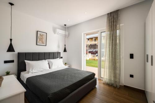 a bedroom with a bed and a large window at Lumino Suites Corfu in Corfu