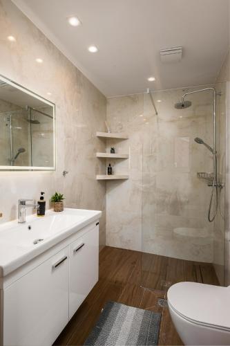 a bathroom with a shower and a sink and a toilet at Lumino Suites Corfu in Corfu