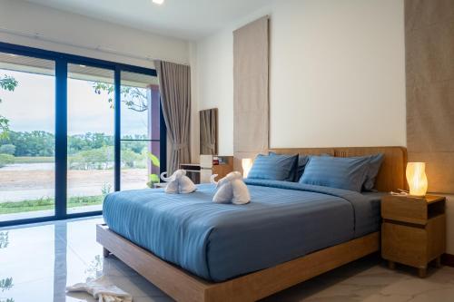 two stuffed animals sitting on a bed in a bedroom at Saree Lagoon Villa Koh Samui in Lipa Noi