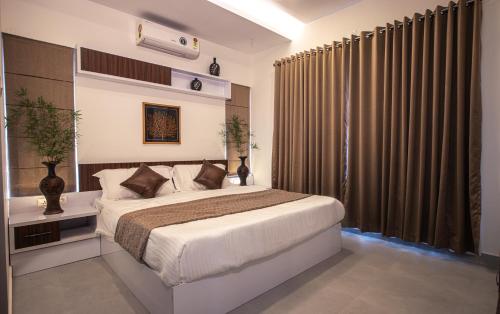 a bedroom with a bed and a large window at Feliz Homes Kottakkal in Kottakkal