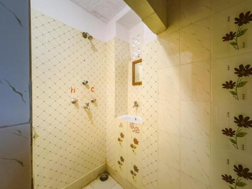a bathroom with a tiled wall with flowers on it at Sagar Guest House in Jaisalmer
