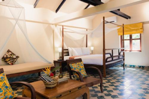 a bedroom with a bed and a table and chairs at Sambor Village Hotel in Kompong Thom
