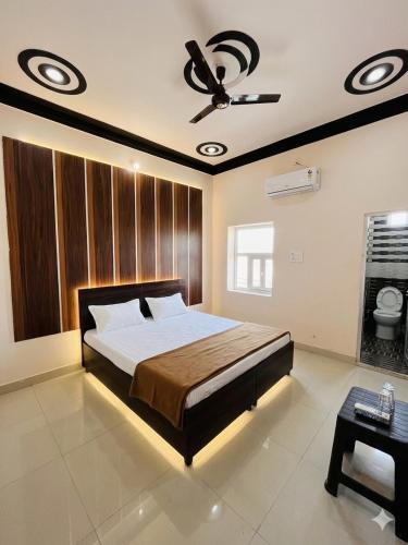 a bedroom with a bed and a ceiling fan at Hotel rahul prime in Gogameri