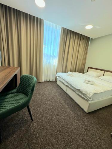 a bedroom with a bed and a chair and a desk at Koncept RK in Banja Luka