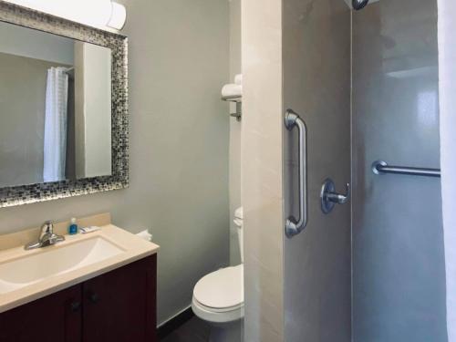 a bathroom with a sink and a toilet and a mirror at Rodeway Inn Old Town Scottsdale in Scottsdale