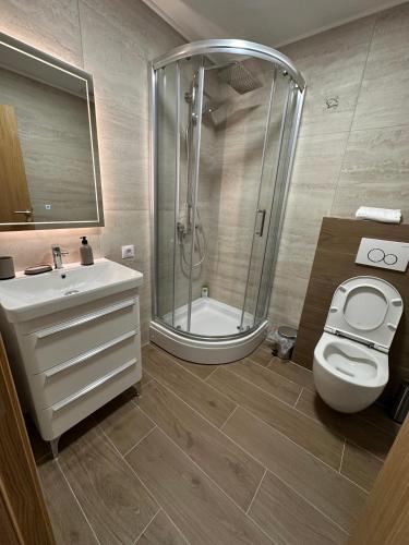 a bathroom with a shower and a toilet and a sink at Koncept RK in Banja Luka