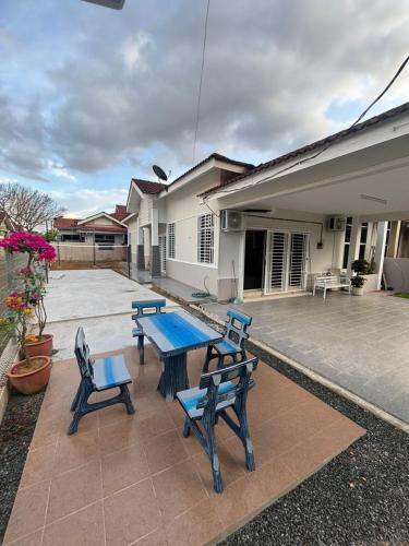 a picnic table and chairs in front of a house at Damai Ria INAP DESA in Jerantut