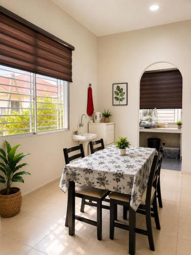 a dining room with a table and chairs and a kitchen at Damai Ria INAP DESA in Jerantut