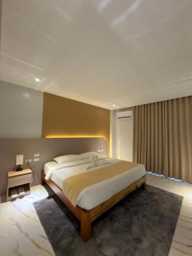 a bedroom with a large bed in a room at Achilles Hotel in Maitim