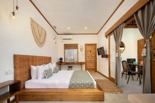 a bedroom with a bed and a desk in a room at Villa Casa Koko in Gili Islands