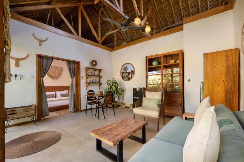 a living room with a blue couch and a table at Villa Casa Koko in Gili Islands